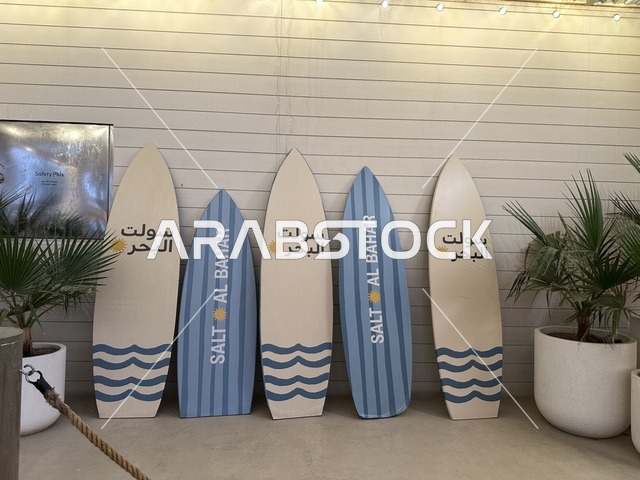 ألواح ركوب الأمواج المعروضة في مكان ما، سولت البحر وجهة ترفيهية وشاطئية عائلية تقع على طريق الكورنيش في الخبر في المملكة العربية السعودية، تجديدات إضافية وتطويرات في 3  يناير 2026، شاطئ رملي مع وجود مظلات وأشجار نخيل