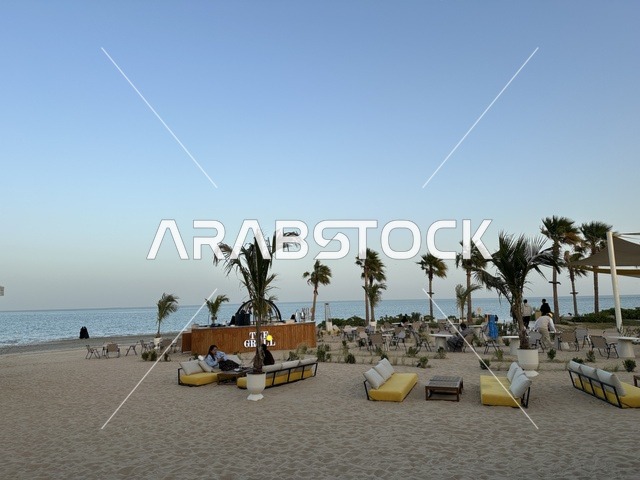 منطقة جلوس خارجية أرائك صفراء وطاولات خشبية، شاطئ رملي مع وجود مظلات وأشجار نخيل، سولت البحر وجهة ترفيهية وشاطئية عائلية تقع على طريق الكورنيش في الخبر في المملكة العربية السعودية، تجديدات إضافية وتطويرات في 3  يناير 2026