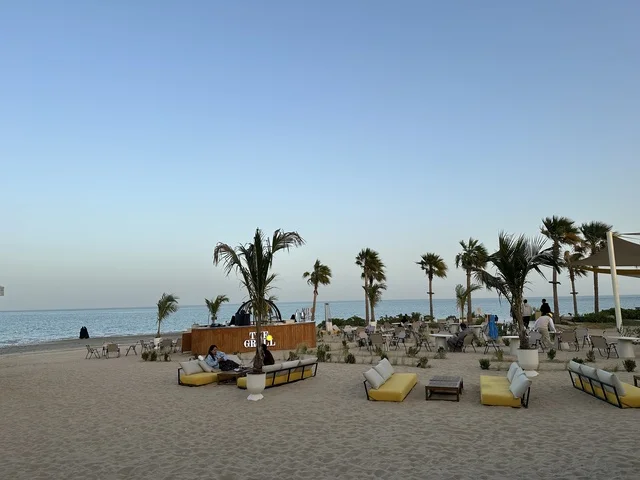 منطقة جلوس خارجية أرائك صفراء وطاولات خشبية، شاطئ رملي مع وجود مظلات وأشجار نخيل، سولت البحر وجهة ترفيهية وشاطئية عائلية تقع على طريق الكورنيش في الخبر في المملكة العربية السعودية، تجديدات إضافية وتطويرات في 3  يناير 2026