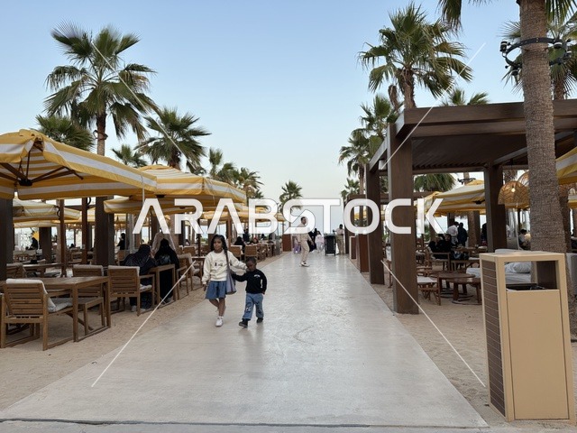 People are sitting and relaxing in the area, Solt Al-Bahr is a recreational and family beach destination located on the Corniche Road in Khobar, Saudi Arabia, a sandy beach with umbrellas and palm trees, additional renovations and developments on January 3, 2026.