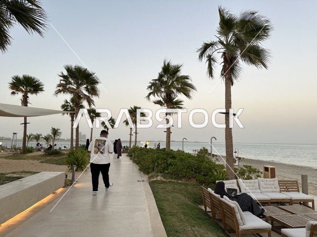 رصيف مشي حديث يمتد على طول الشاطئ، سولت البحر وجهة ترفيهية وشاطئية عائلية تقع على طريق الكورنيش في الخبر في المملكة العربية السعودية، تجديدات إضافية وتطويرات في 3  يناير 2026، شاطئ رملي مع وجود مظلات وأشجار نخيل