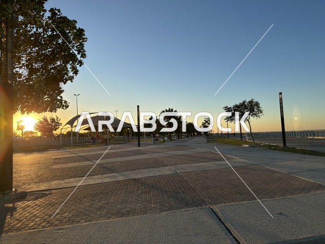 مساحة واشجار ونباتات خضراء، الواجهة البحرية في مدينة الدمام في وقت الغروب، منطقة حيوية ومتنفس رئيسي لسكان وزوار المنطقة الشرقية، كورنيش مطل على الخليج العربي في المملكة العربية السعودية