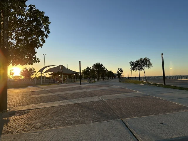 مساحة واشجار ونباتات خضراء، الواجهة البحرية في مدينة الدمام في وقت الغروب، منطقة حيوية ومتنفس رئيسي لسكان وزوار المنطقة الشرقية، كورنيش مطل على الخليج العربي في المملكة العربية السعودية