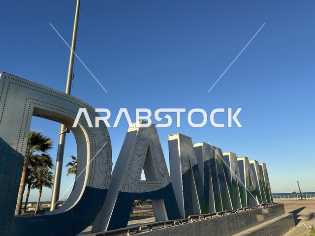 مجسم كلمة الدمام باللغة الانجليزية، الواجهة البحرية في مدينة الدمام في وقت النهار، منطقة حيوية ومتنفس رئيسي لسكان وزوار المنطقة الشرقية، كورنيش مطل على الخليج العربي في المملكة العربية السعودية