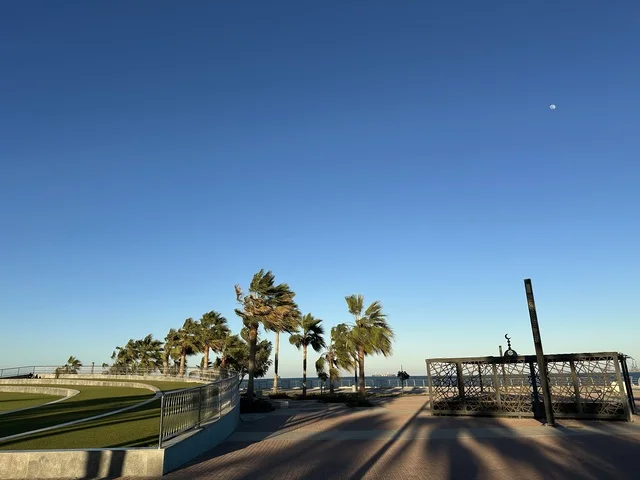 كورنيش مطل على الخليج العربي في المملكة العربية السعودية، اشجار خضراء في ممشى الواجهة البحرية في مدينة الدمام، منطقة حيوية ومتنفس رئيسي لسكان وزوار المنطقة الشرقية