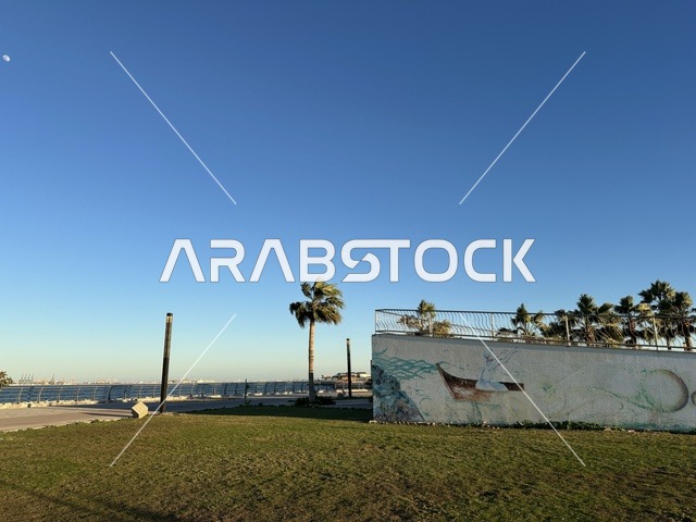 كورنيش مطل على الخليج العربي في المملكة العربية السعودية، اشجار خضراء في ممشى الواجهة البحرية في مدينة الدمام، منطقة حيوية ومتنفس رئيسي لسكان وزوار المنطقة الشرقية