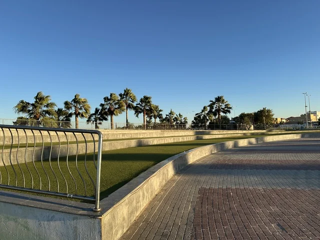 A corniche overlooking the Arabian Gulf in the Kingdom of Saudi Arabia, green trees along the waterfront promenade in the city of Dammam, a vibrant area and a main outlet for residents and visitors of the Eastern Province.