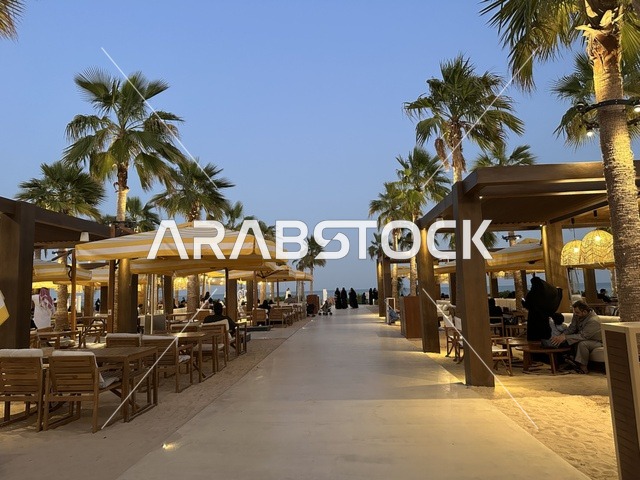 أرضية رملية في منطقة الجلوس، سولت البحر وجهة ترفيهية وشاطئية عائلية تقع على طريق الكورنيش في الخبر في المملكة العربية السعودية، تجديدات إضافية وتطويرات في 3  يناير 2026، شاطئ رملي مع وجود مظلات وأشجار نخيل