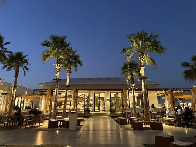 تصميم معماري حديث مع صفوف من الأعمدة ، سولت البحر وجهة ترفيهية وشاطئية عائلية تقع على طريق الكورنيش في الخبر في المملكة العربية السعودية، تجديدات إضافية وتطويرات في 3  يناير 2026، شاطئ رملي مع وجود مظلات وأشجار نخيل