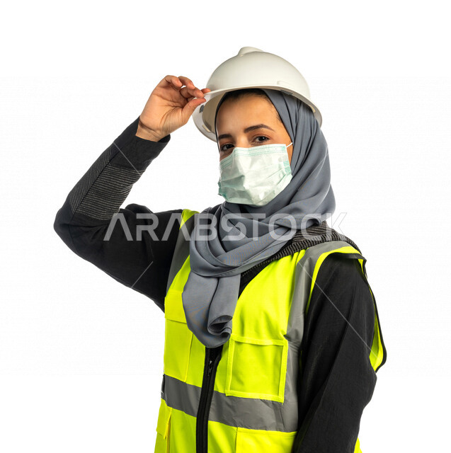 بورتريه مهندسة معمارية عربية سعودية خليجية تضع خوذة السلامة ، مهندسة انشاءات محجبة ترتدي بدلة السلامة في العمل ، لباس رسمي للعمل ، مشروع بناء ، خلفية بيضاء