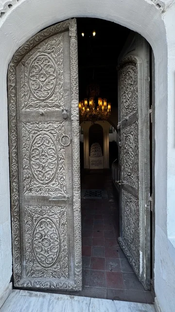 A wooden door intricately carved and decorated, architectural arts in the historic city of Jeddah, drone photography of alleys and traditional designs, tourist attractions in the Kingdom of Saudi Arabia, ancient archaeological buildings, revitalization projects in the area.