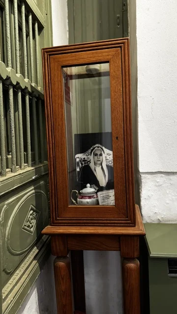 عرض صور لشخصيات في صندوق خشبي قديم، معلومات في إطار تعليمي أو بحثي، المستندات الشخصية والرسمية، وثائق تاريخية وأرشيفية معروضة في متحف في جدة التاريخية في المملكة العربية السعودية، مقتنيات تذكارية وعناصر ذات قيمة ثقافية.