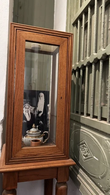 صندوق خشبي قديم بداخله صورة قديمة، معلومات في إطار تعليمي أو بحثي، المستندات الشخصية والرسمية، وثائق تاريخية وأرشيفية معروضة في متحف في جدة التاريخية في المملكة العربية السعودية، مقتنيات تذكارية وعناصر ذات قيمة ثقافية.