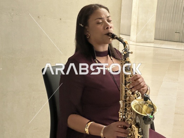 فنانة تقوم بالعزف على آلة ساكسفون فى مهرجان للطعام فى حدائق إثراء الخارجية بالظهران، الشرقية ، المملكة العربية السعودية، يوم 28 من ديسمبر 2025 ، مطاعم دولية ومحلية ، جلسات خارجية ممتعه ، تجربة طعام عالمية، أجواء عائلية وترفيهية