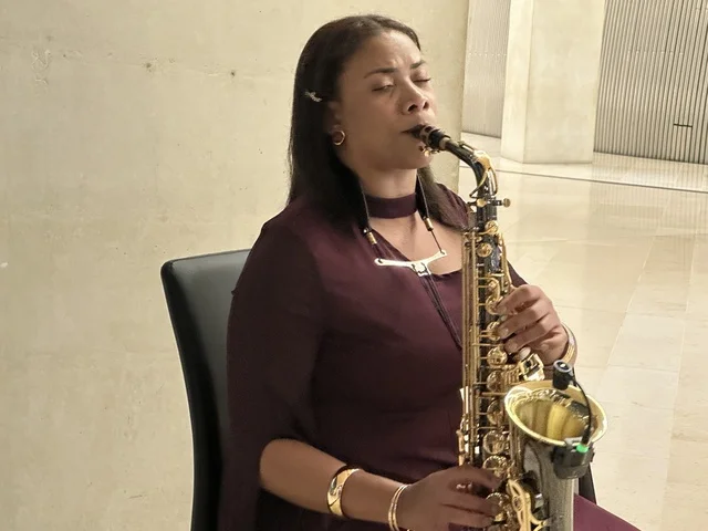 An artist is playing the saxophone at a food festival in the outdoor gardens of Ithra in Dhahran, Eastern Province, Saudi Arabia, on December 28, 2025. There are international and local restaurants, enjoyable outdoor seating, a global dining experience, and a family-friendly and entertaining atmosphere.
