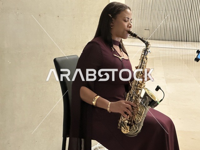 فنانة تقوم بالعزف على آلة ساكسفون فى مهرجان للطعام فى حدائق إثراء الخارجية بالظهران، الشرقية ، المملكة العربية السعودية، يوم 28 من ديسمبر 2025 ، مطاعم دولية ومحلية ، جلسات خارجية ممتعه ، تجربة طعام عالمية، أجواء عائلية وترفيهية