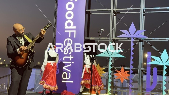 عزف على الجيتار ورقصة فلكلورية مكسيكية فى  مهرجان للطعام فى حدائق إثراء الخارجية بالظهران، الشرقية ، المملكة العربية السعودية، يوم 28 من ديسمبر 2025 ،  تجربة تذوق عالمية ، أجواء عائلية وترفيهية، جلسات خارجية ممتعه، مطاعم دولية ومحلية