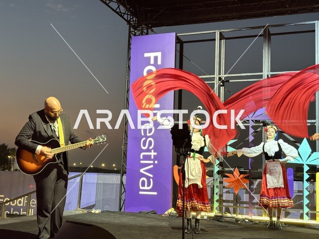 عزف على الجيتار ورقصة فلكلورية مكسيكية فى  مهرجان للطعام فى حدائق إثراء الخارجية بالظهران، الشرقية ، المملكة العربية السعودية، يوم 28 من ديسمبر 2025 ،  تجربة تذوق عالمية ، أجواء عائلية وترفيهية، جلسات خارجية ممتعه، مطاعم دولية ومحلية