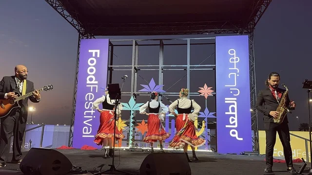 عزف على الجيتار ورقصة فلكلورية مكسيكية فى  مهرجان للطعام فى حدائق إثراء الخارجية بالظهران، الشرقية ، المملكة العربية السعودية، يوم 28 من ديسمبر 2025 ،  تجربة تذوق عالمية ، أجواء عائلية وترفيهية، جلسات خارجية ممتعه، مطاعم دولية ومحلية