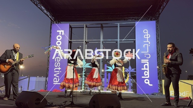 عزف على الجيتار ورقصة فلكلورية مكسيكية فى  مهرجان للطعام فى حدائق إثراء الخارجية بالظهران، الشرقية ، المملكة العربية السعودية، يوم 28 من ديسمبر 2025 ،  تجربة تذوق عالمية ، أجواء عائلية وترفيهية، جلسات خارجية ممتعه، مطاعم دولية ومحلية