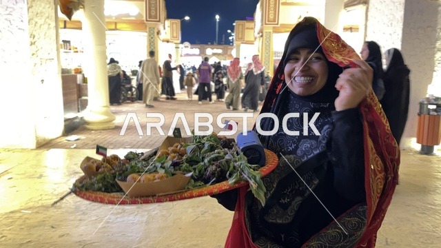 سيدة تقوم بتقديم الطعام في المدينة العالمية يناير 2026 على ضفاف الخليج العربي وبحيرة سيهات في المنطقة الشرقية الدمام، وجهة ترفيهية وثقافية موسمية، مكان لقضاء وقت ممتع مع العائلة