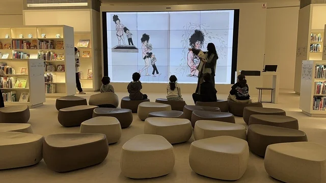 A storytelling presentation on a digital screen, a cultural activity for children inside the library, an interior image of the Ithra Library in the Dhahran area of the Kingdom of Saudi Arabia, a cultural beacon from the heart of the Kingdom to the world, the King Abdulaziz Center for World Culture.