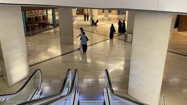 ممر داخلي واسع داخل مبنى ثقافي حديث، سلالم كهربائية بتصميم عصري، حركة الزوار داخل المساحة الداخلية، أجواء هادئة وتنظيم معماري معاصر، مركز الملك عبد العزيز الثقافي العالمي (إثراء) في الظهران بالمنطقة الشرقية في المملكة العربية السعودية