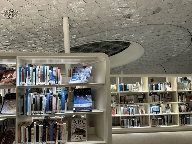 مساحة قراءة ومعرفة بتصميم داخلي عصري، أرفف كتب متنوعة، سقف هندسي مميز يعكس الابتكار المعماري، بيئة تعليمية هادئة، مكتبة مركز الملك عبدالعزيز للثقافة العالمية (إثراء) في الظهران