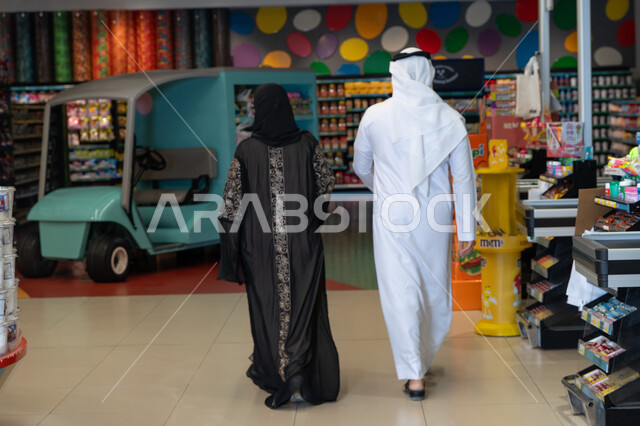 زوجان عربيان يتسوقان داخل متجر تجاري حديث