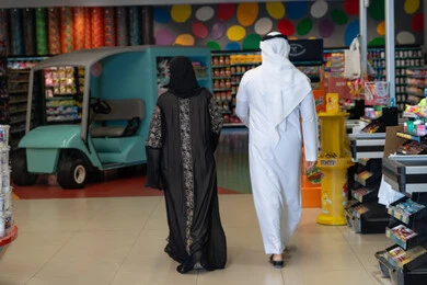 زوجان عربيان يتسوقان داخل متجر تجاري حديث