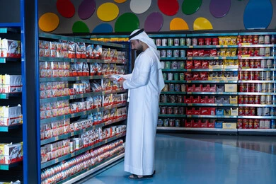 رجل إماراتي يتسوق في ممر السوبر ماركت