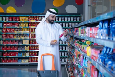 رجل إماراتي يتسوق داخل سوبر ماركت حديث