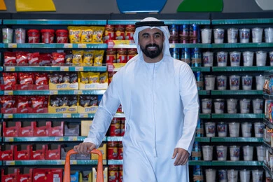 رجل إماراتي مع عربة تسوق في السوبر ماركت