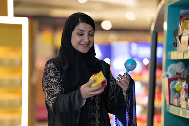 Saudi Woman Shopping for Toys in Modern Retail Store