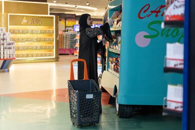 امرأة عربية تتسوق الحلويات في مركز تجاري حديث