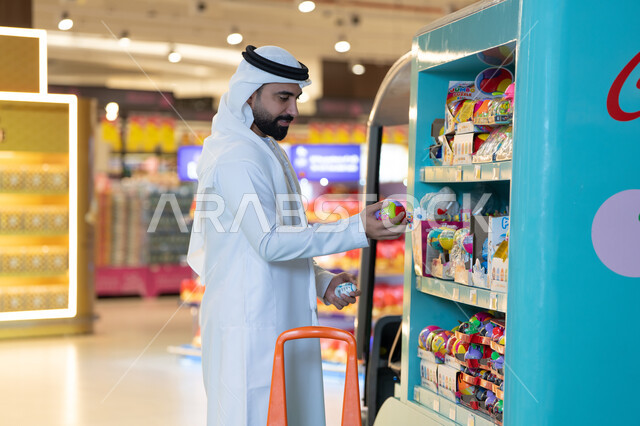 رجل إماراتي يتسوق في متجر ألعاب داخل مول