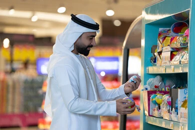 رجل إماراتي يتسوق ألعاب في متجر تجزئة