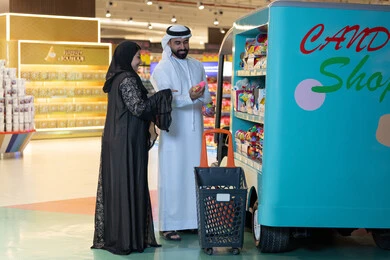 زوج إماراتي يتسوق في متجر حلويات داخل مول