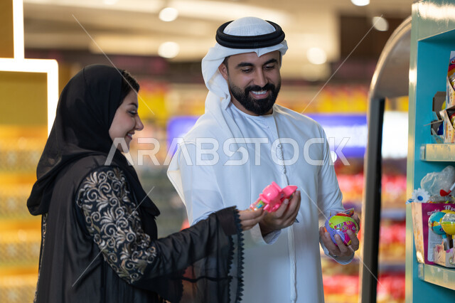 زوجان إماراتيان يتسوقان في متجر ألعاب داخل مول