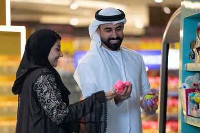 زوجان إماراتيان يتسوقان في متجر ألعاب داخل مول