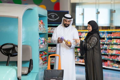 زوجين إماراتيين يتسوقان الألعاب في سوبر ماركت