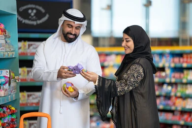 زوجان إماراتيان يتسوقان لشراء الألعاب في المتجر