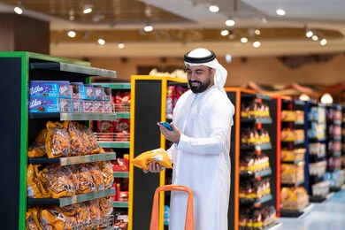 Arab Man Shopping in Supermarket with Smartphone