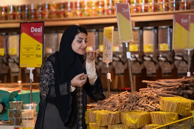 Arab Woman Smelling Spices in Supermarket