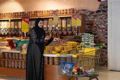 Saudi Woman Shopping with Cart in Modern Supermarket