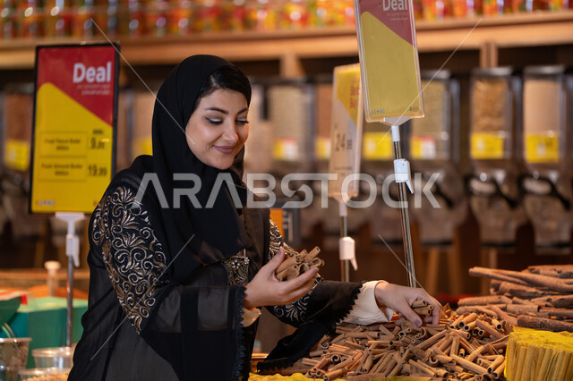امرأة سعودية تختار أعواد القرفة في متجر توابل