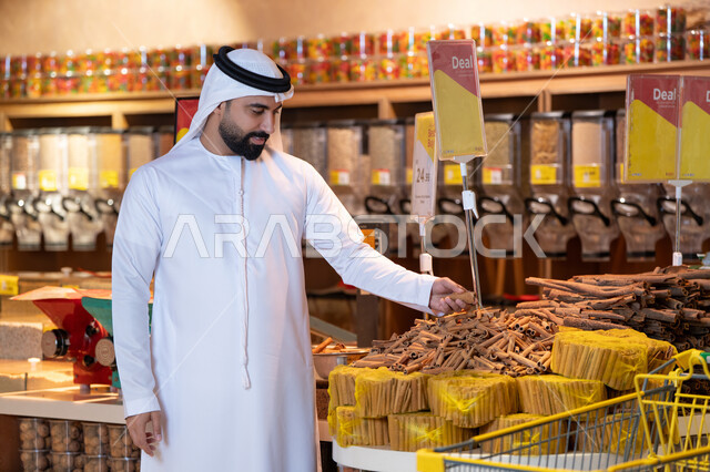 رجل إماراتي يتسوق البهارات في السوبر ماركت