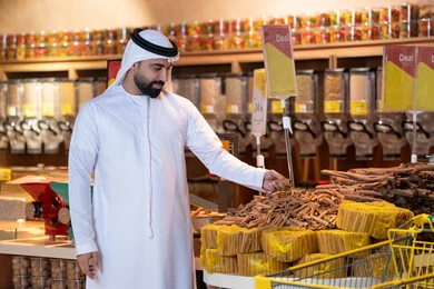 رجل إماراتي يتسوق البهارات في السوبر ماركت