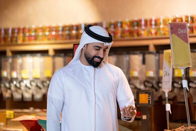 رجل إماراتي يتسوق في متجر بقالة حديث