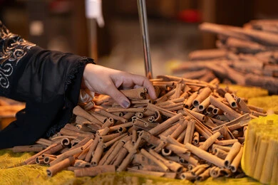 امرأة سعودية تختار أعواد القرفة في سوق تقليدي